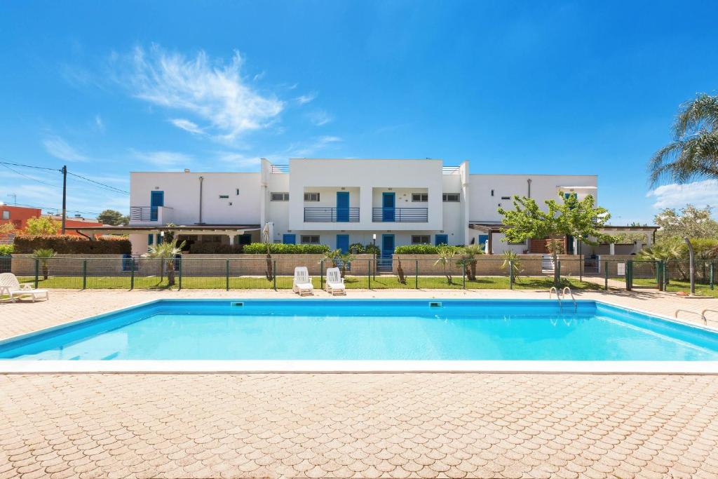a swimming pool in front of a house at Appartamento Cristallo by BarbarHouse in Torre Lapillo