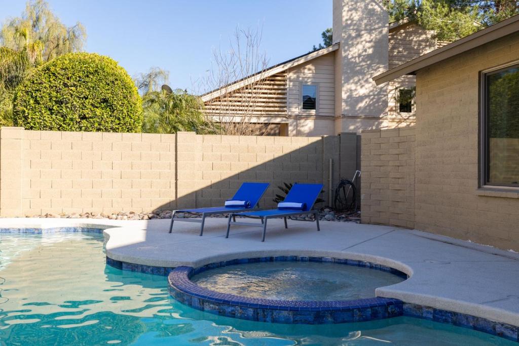 twee blauwe stoelen naast een zwembad bij Scottsdale Friess home in Scottsdale