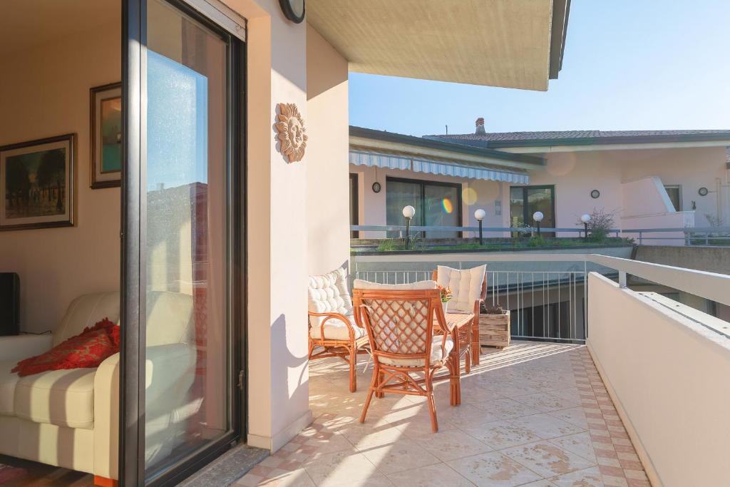patio z kanapą i krzesłami na balkonie w obiekcie Kristall Lago 233 Apartment by Wonderful Italy w mieście Desenzano del Garda