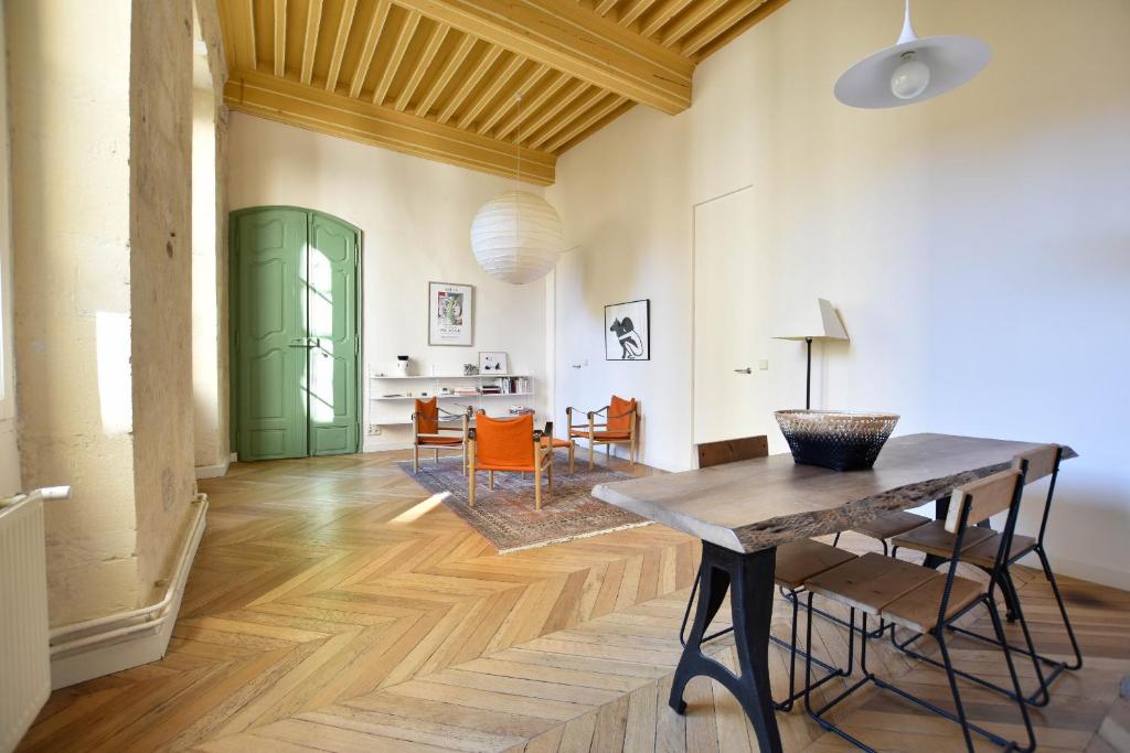 - un salon avec une table et des chaises en bois dans l'établissement St Honoré - Appart Design, à Arles