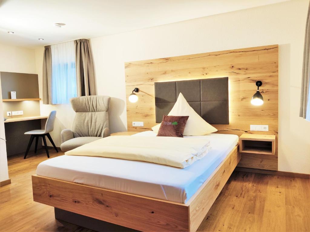 um quarto de hotel com uma cama grande e uma cadeira em Hotel Restaurant Zur Linde em Erbach