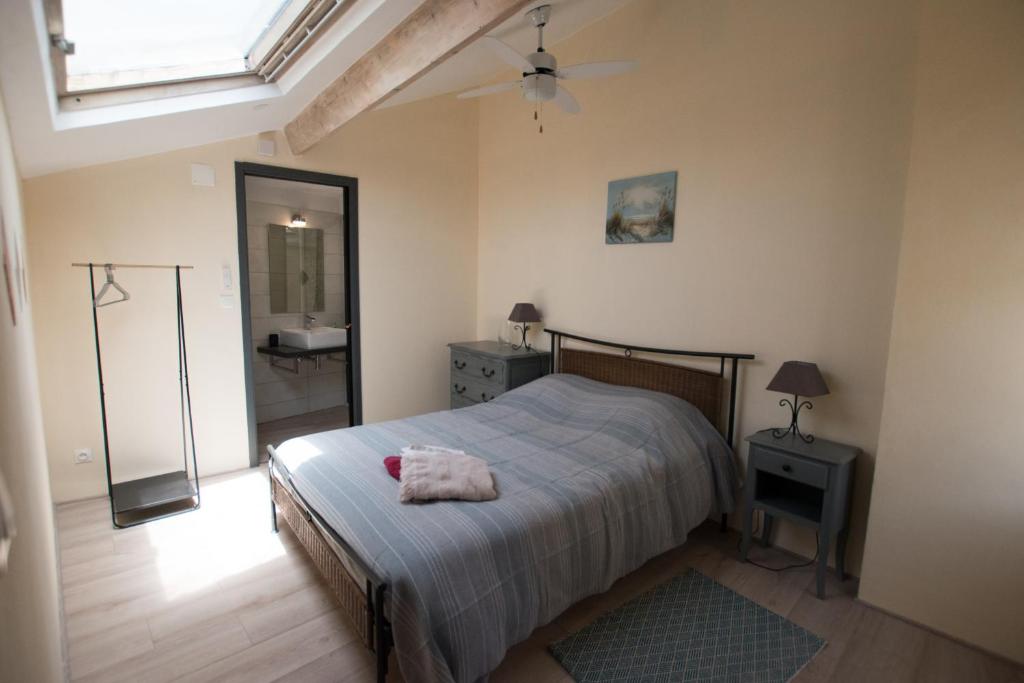 1 dormitorio con cama, espejo y lavamanos en Madeleine - Maison proche des Arènes en Arlés