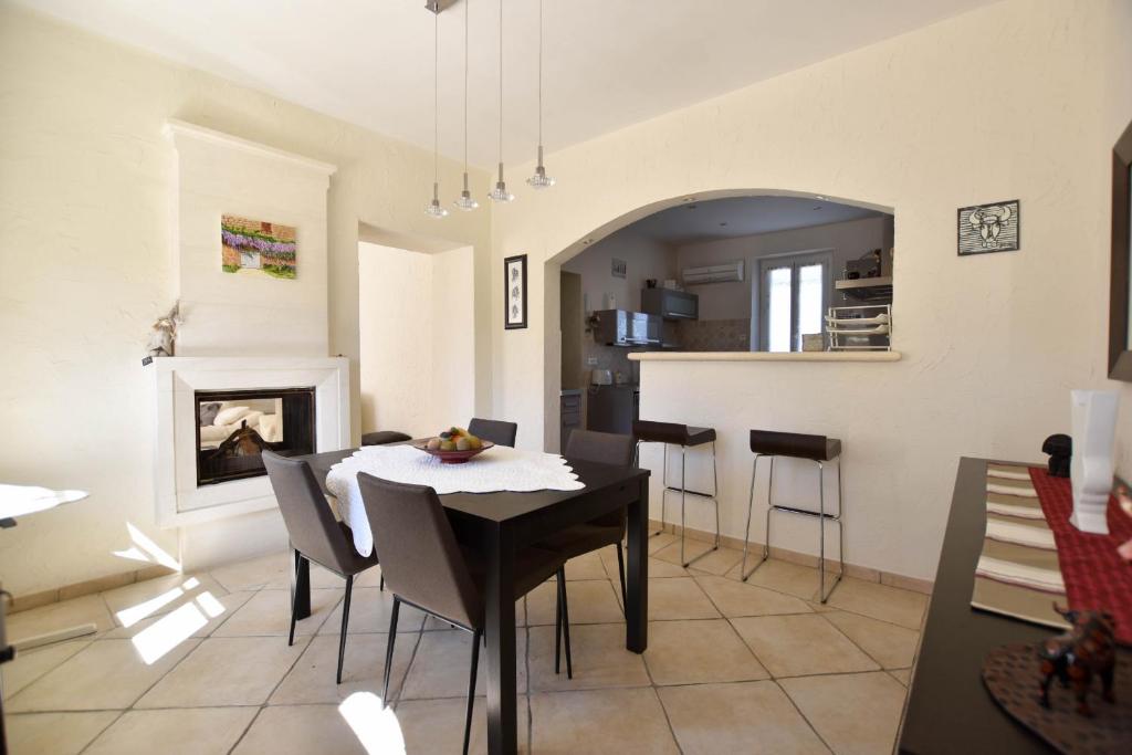 eine Küche und ein Esszimmer mit einem Tisch und Stühlen in der Unterkunft Margaillan - Parking - Jardin - Clim in Arles