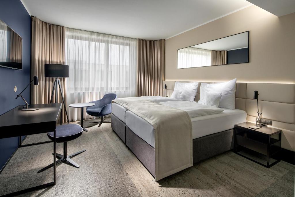 a hotel room with a bed and a desk and a mirror at Clarion Congress Hotel Prague in Prague