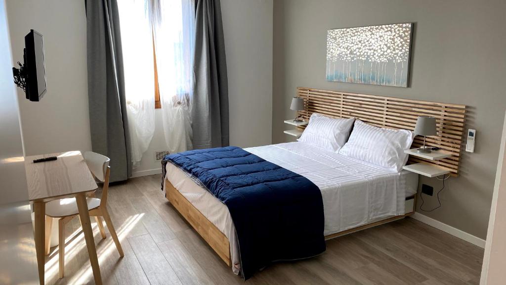 a bedroom with a large bed with a blue blanket at Foresteria Green House in Seriate