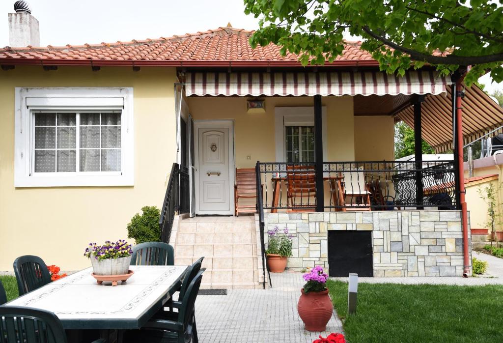 a patio with a table and chairs in front of a house at Summer Panorama Retreat - Yard, Barbeque, up to 7 in Epanomi