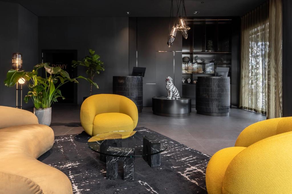 a living room with yellow chairs and a coffee table at Hotel ROMY by AMANO in Berlin