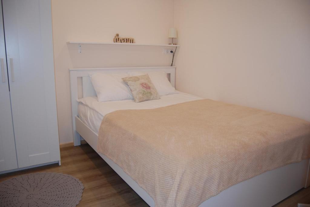a bedroom with a bed with a white headboard at LiisuPesa Apartment with Sauna and Garden in Pärnu