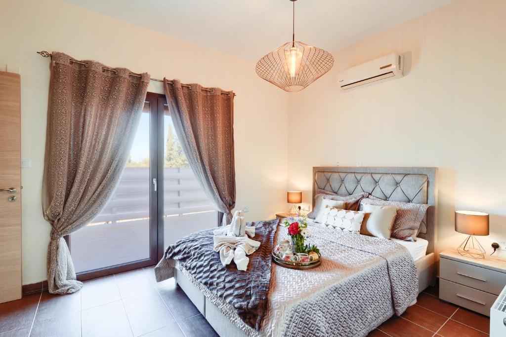 sypialnia z łóżkiem i dużym oknem w obiekcie Alkistias & Konstantinos Villa w mieście Latsi