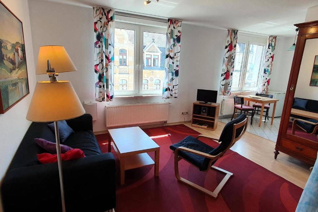 een woonkamer met een bank, stoelen en een tafel bij Laurin Apartment L65 in Dresden