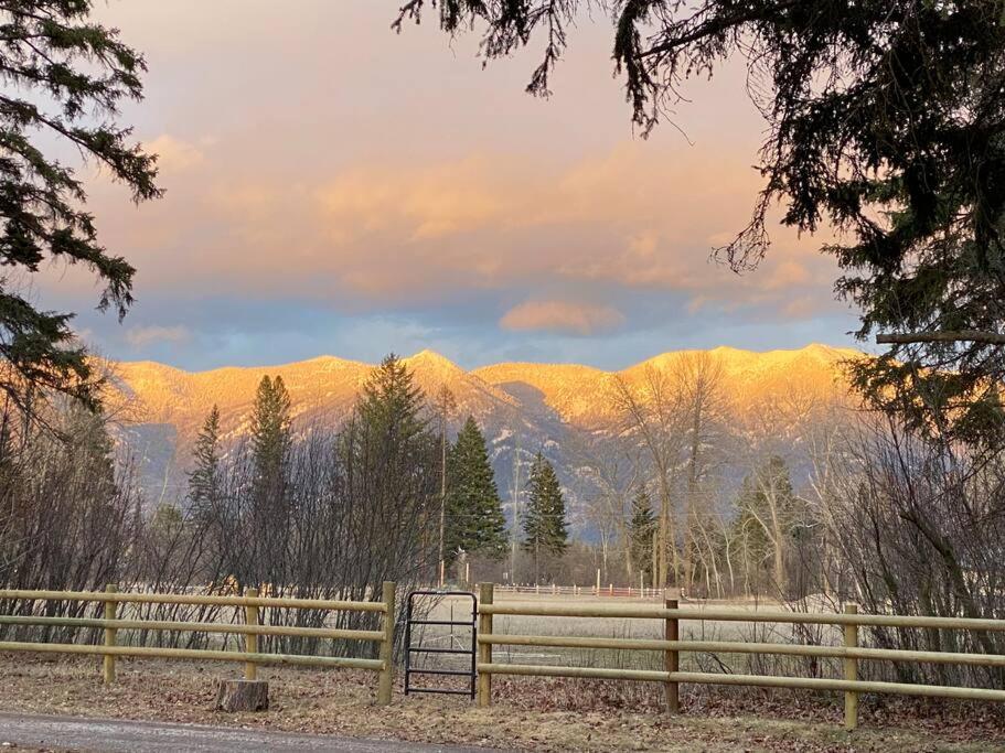 une clôture en bois avec des montagnes en arrière-plan dans l'établissement Swan Mountain View-Private Basement Suite/10 acres, à Kalispell