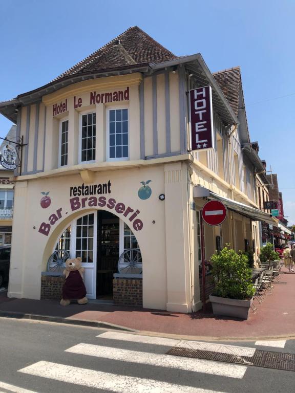 un ours en peluche dans la fenêtre d'un magasin dans l'établissement Hotel Le Normand, à Houlgate