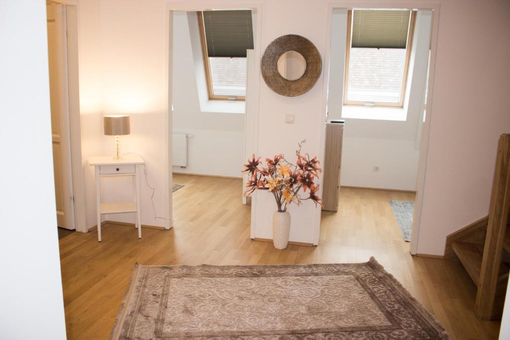 un soggiorno con un vaso con fiori di Sunny & cozy Penthouse with Terrace DG3 QS12 a Vienna