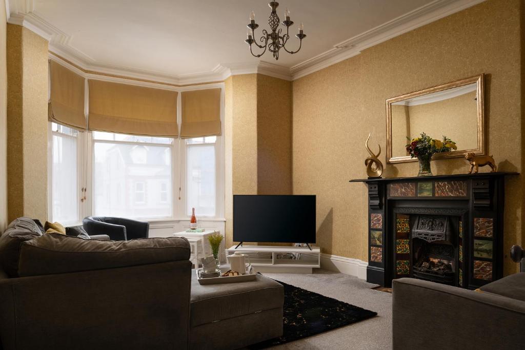a living room with a television and a fireplace at The North Shore in Llandudno