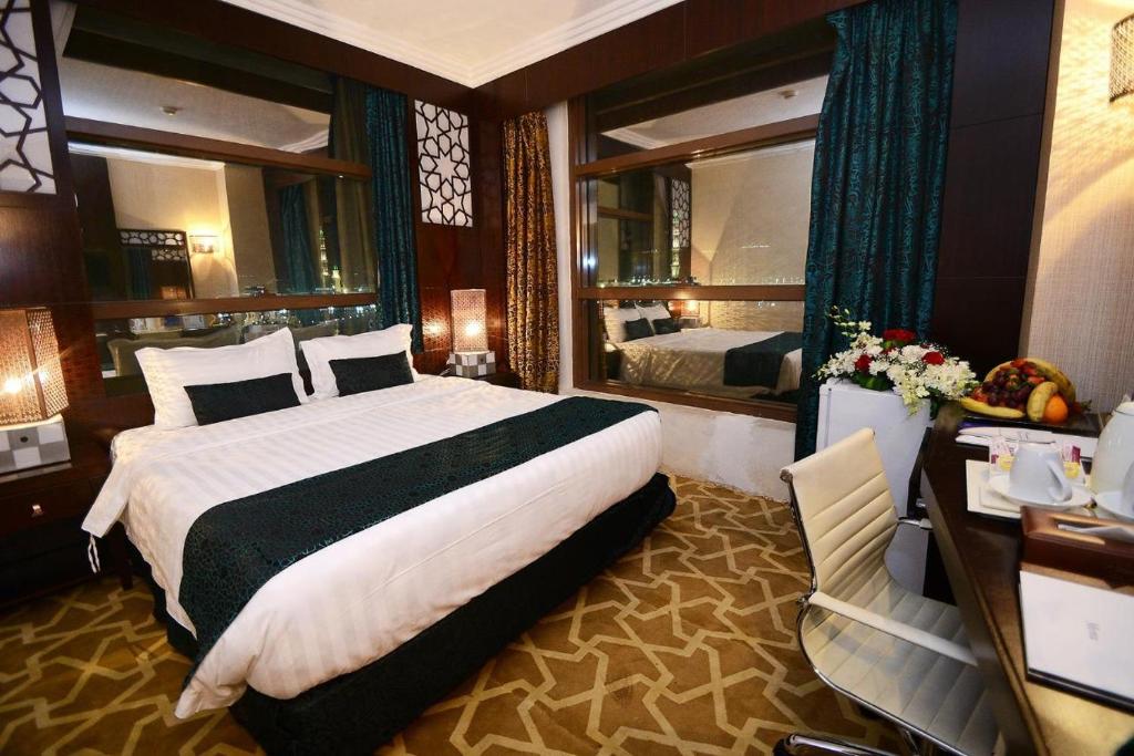 Habitación de hotel con cama grande y espejo en Rawdat Al Safwa Hotel en Medina