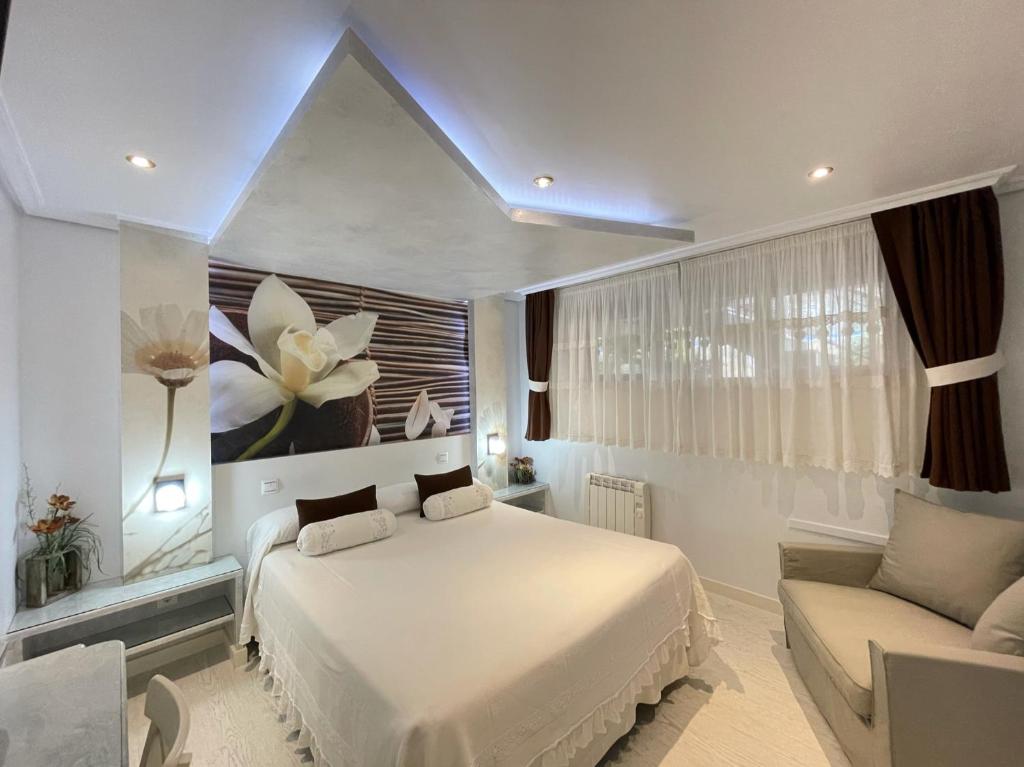 a bedroom with a white bed and a couch at El Jardin in Soto de la Marina