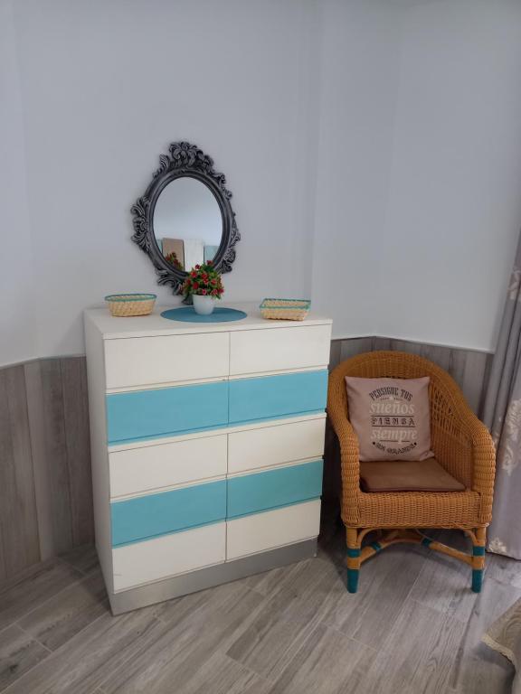 een dressoir met een spiegel en een stoel bij Casa mary in Costa de Antigua