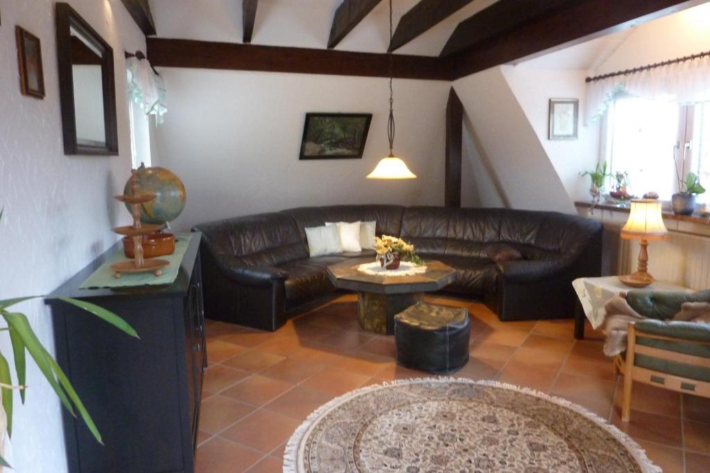 a living room with a leather couch and a table at Ferienwohnung Haus Anne in Büdelsdorf