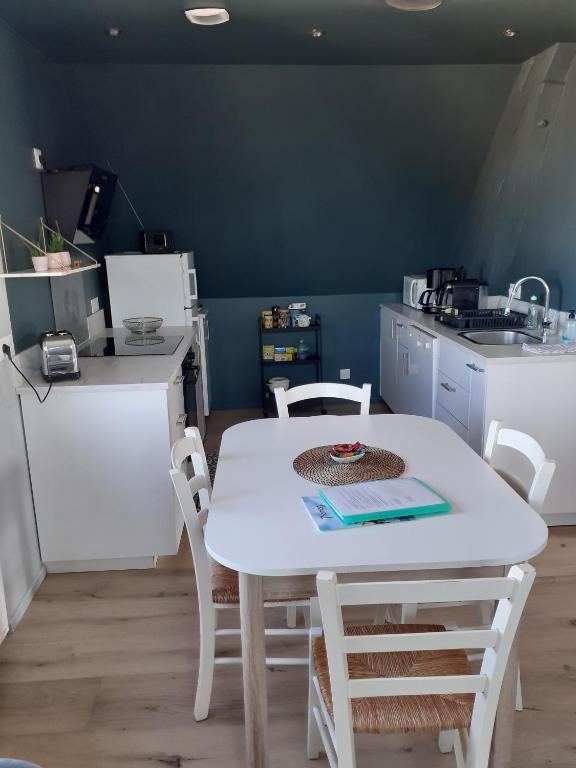 cocina con mesa blanca y sillas blancas en CHARMANT APPARTEMENT à 150 M des THERMES et du CENTRE VILLE, en Thonon-les-Bains