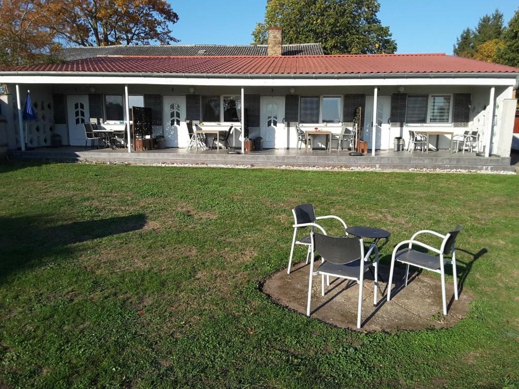 two chairs and a table in front of a house at Ruegen Fewo 168 in Zudar