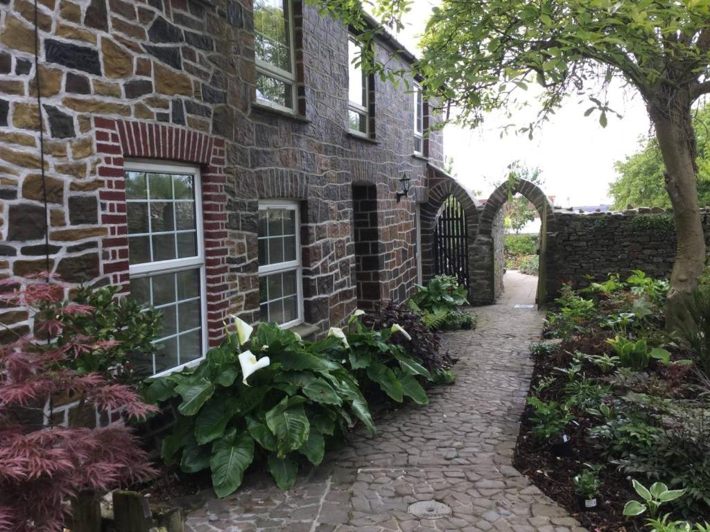 uma casa de pedra com um jardim e uma passagem de pedra em The Hermitage em Great Torrington