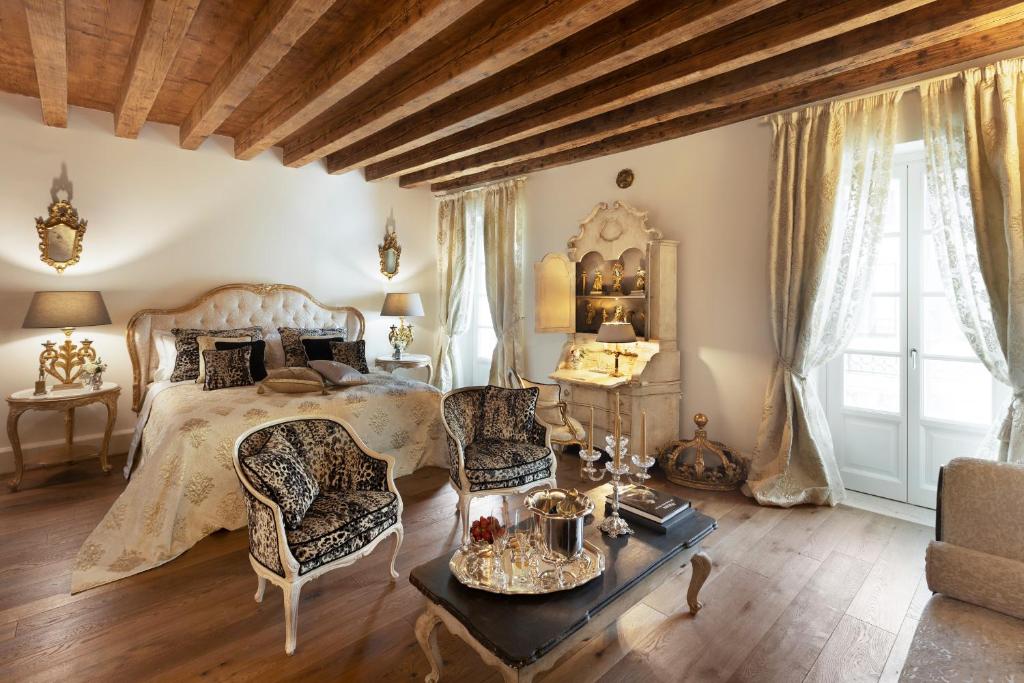 Antica Dimora Desenzano في ديسينسانو ديل غاردا: غرفة نوم بسرير وطاولة وكراسي