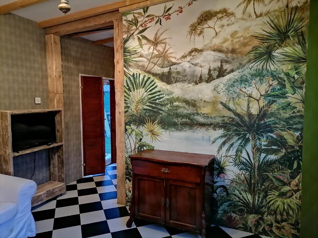 een kamer met een muurschildering aan de muur bij Villa Le Jardin in Oude Pekela