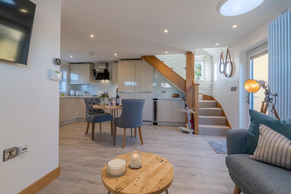 a living room and kitchen with a couch and a table at Hillview Hideaway with Hot Tub in Cheltenham