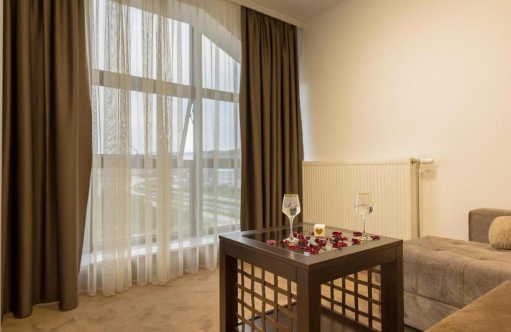 a living room with a large window and a table with candles at LuxA Apartmani in Novi Pazar