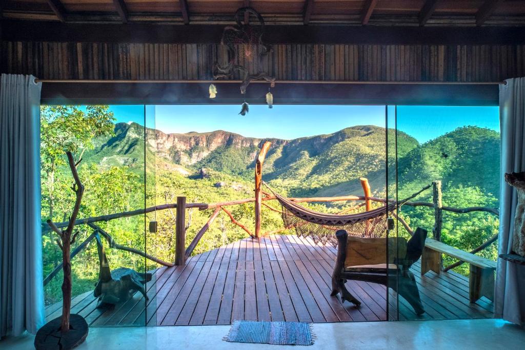 a room with a hammock and a view of the mountains at Ecopousada Toca do Guará in Alto Paraíso de Goiás