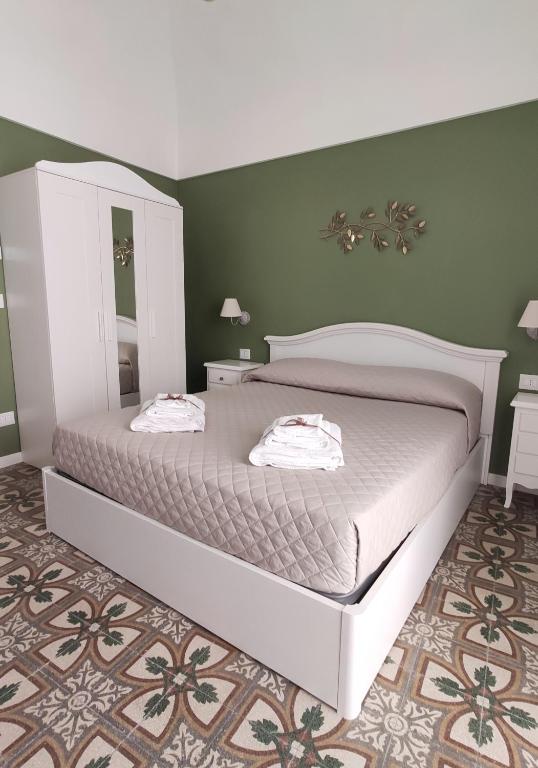 a bedroom with a large bed and green walls at Dimora della Nonna-Luxury Home in Mola di Bari