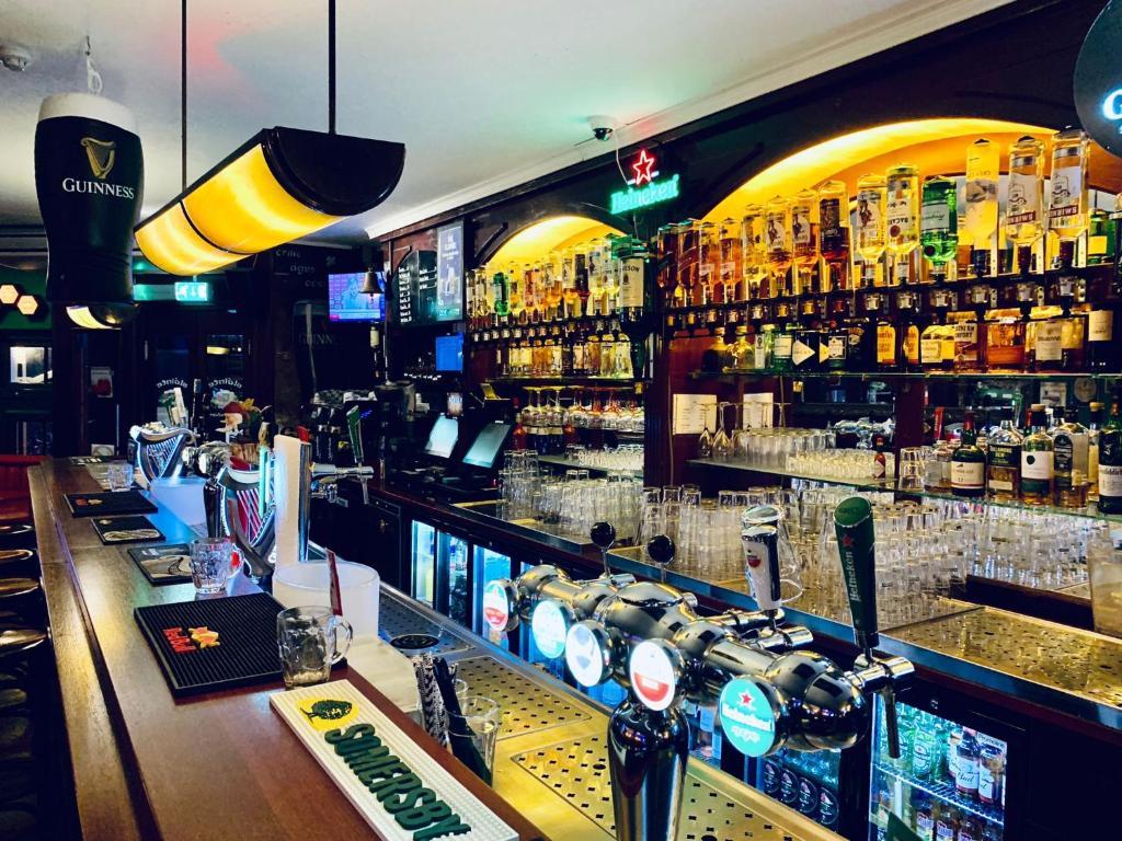 a bar filled with lots of bottles of alcohol at The White Tulip Hostel in Amsterdam