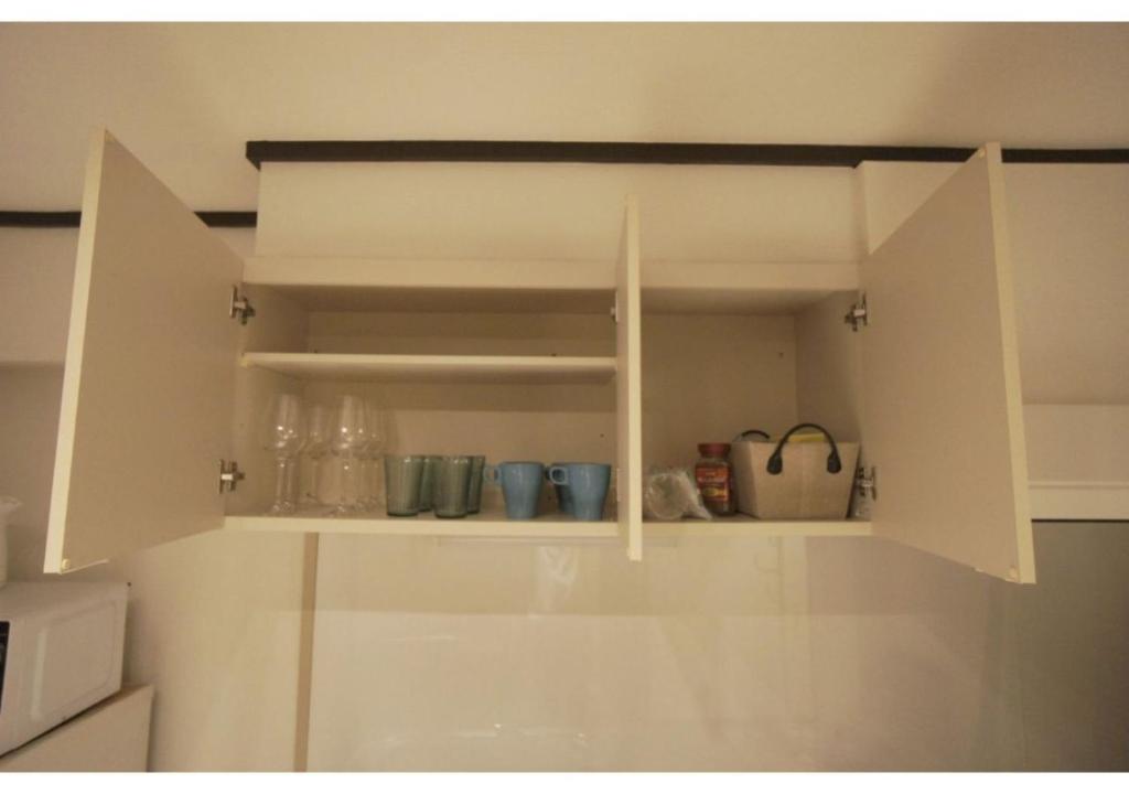 um armário branco com copos na cozinha em Woody Sanheim - Vacation STAY 12558 em Tóquio