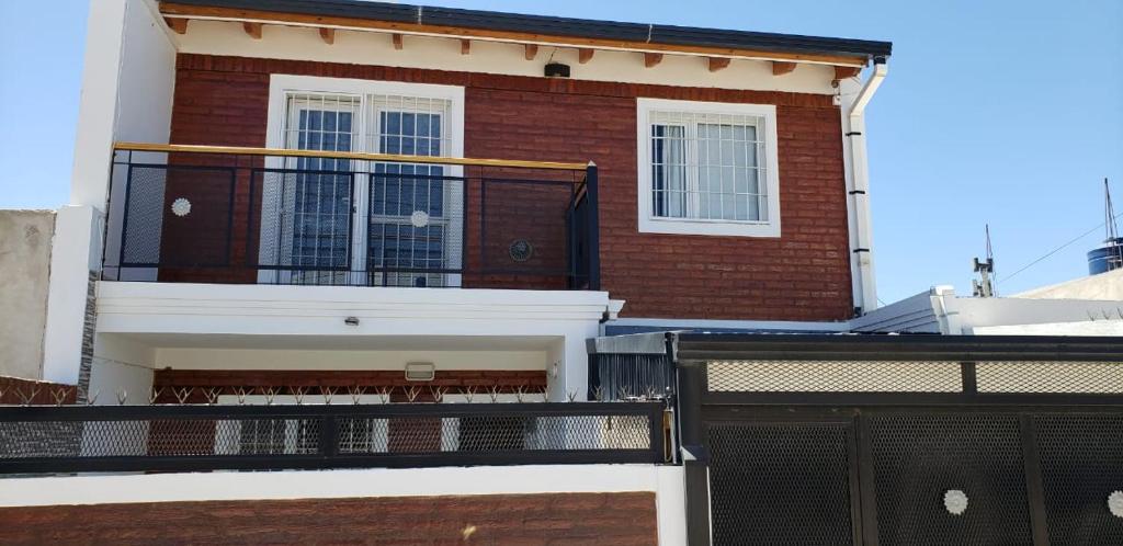 a red brick building with a balcony in front of it at MAR & ARENA in Puerto Madryn