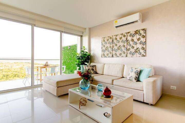 sala de estar con sofá y mesa en Hermoso apartamento con todas las comodidades acceso directo a la playa Morros Epic sector La Boquilla cumple protocolos de bioseguridad, en Cartagena de Indias