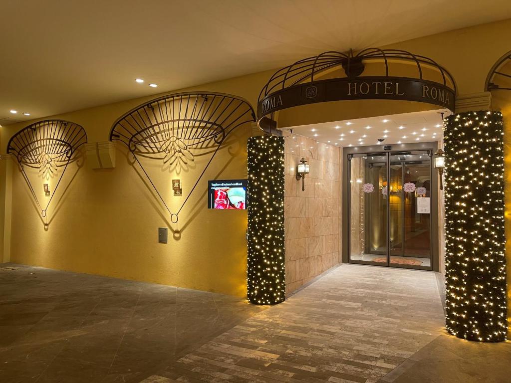 a hotel lobby with a hotel sign on the wall at Hotel Roma in Bologna