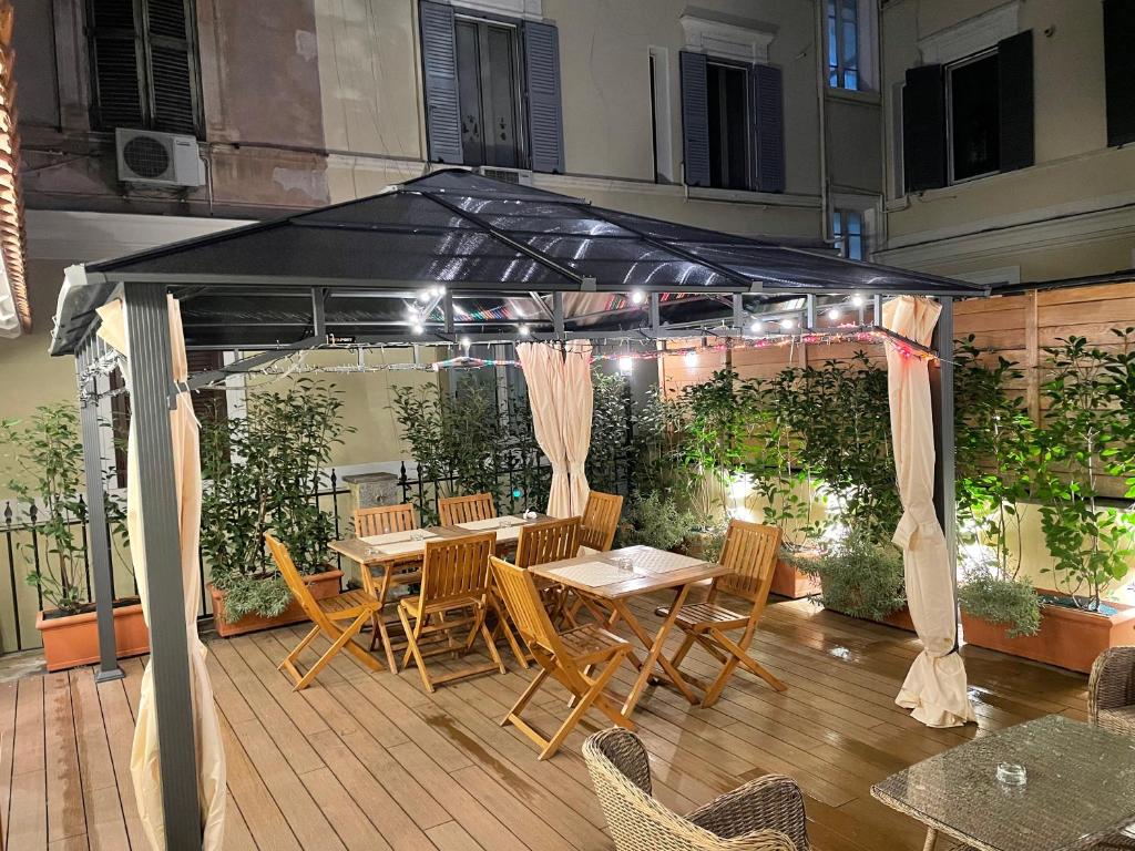 d'une terrasse avec une table et des chaises sous un auvent. dans l'établissement Art Atelier Risorgimento, à Rome
