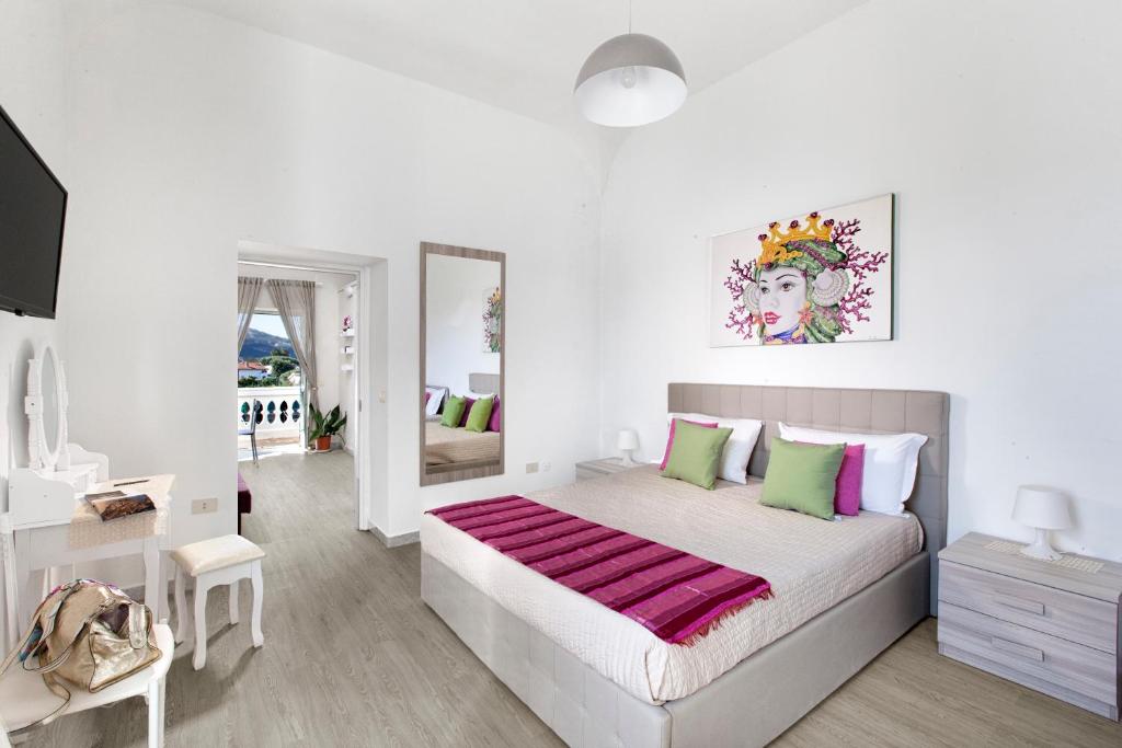 Dormitorio blanco con cama grande con almohadas rosas y verdes en Estate4Home - Villa Lina en Sant'Agnello