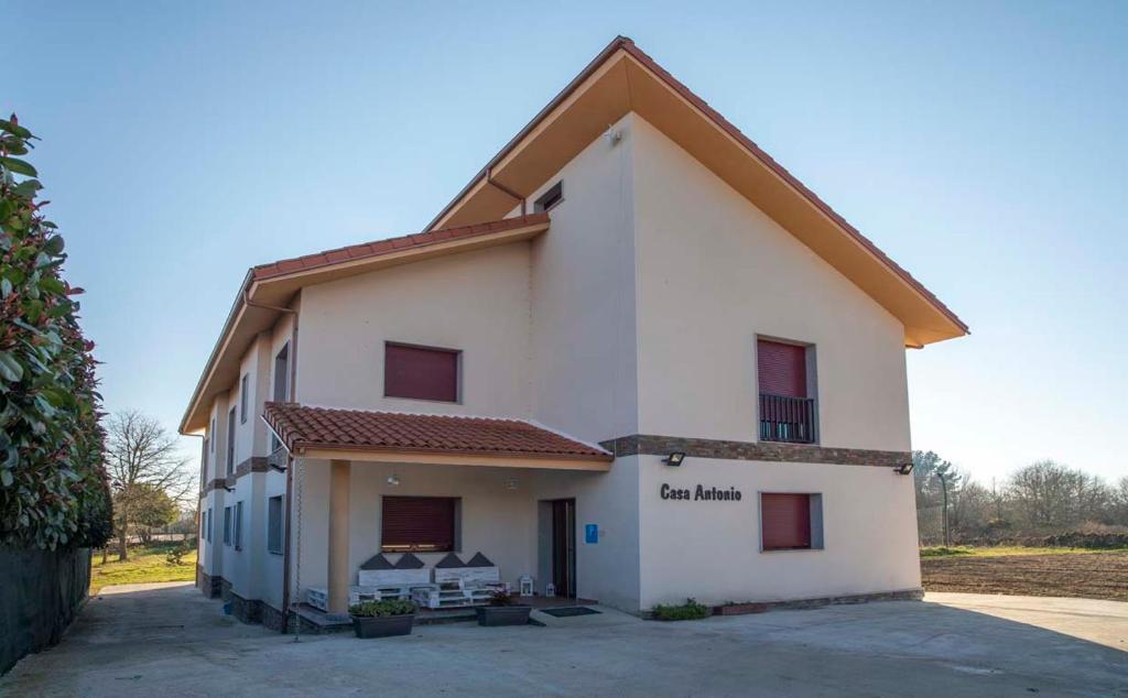 un edificio blanco con un cartel en el costado en PENSIÓN CASA ANTONIO, en Pantón