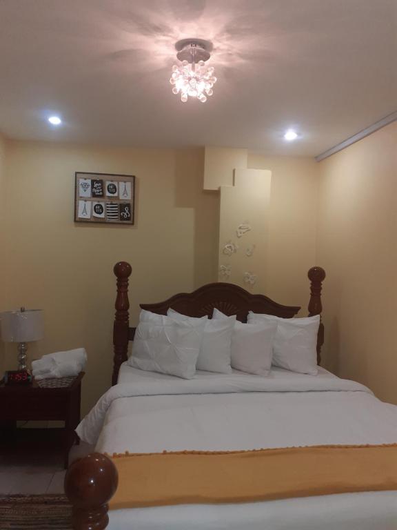 1 dormitorio con 1 cama grande con almohadas blancas en Essentials Suite, en Bon Accord