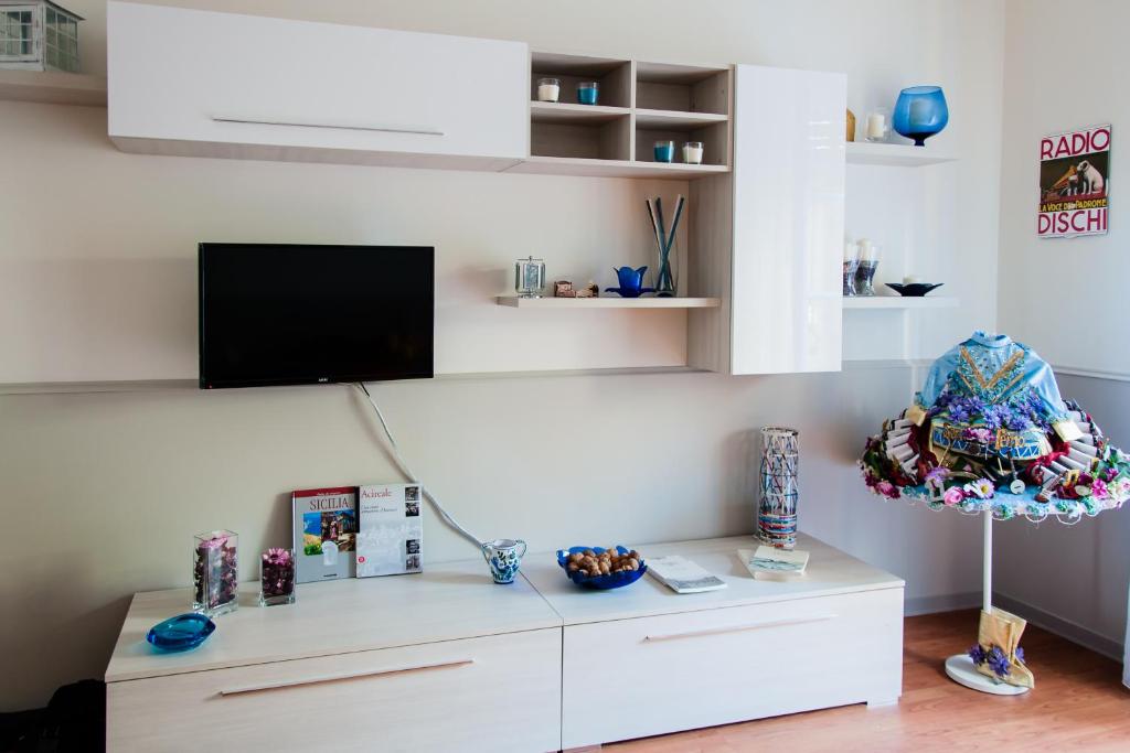 Appartampeppe في أتشيريالي: غرفة معيشة مع خزانة بيضاء وتلفزيون