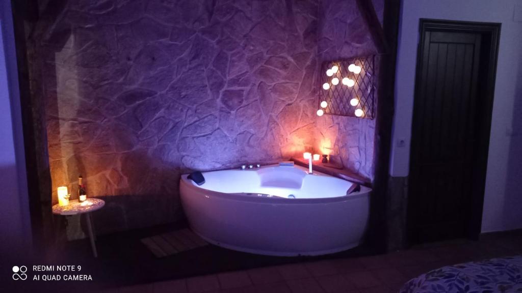 bañera en una habitación con 2 velas en La Casa de la Lobita, en Benaocaz