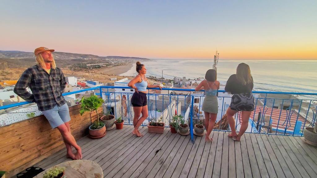 a group of people standing on a deck looking at the ocean at Kekai Surf House in Taghazout