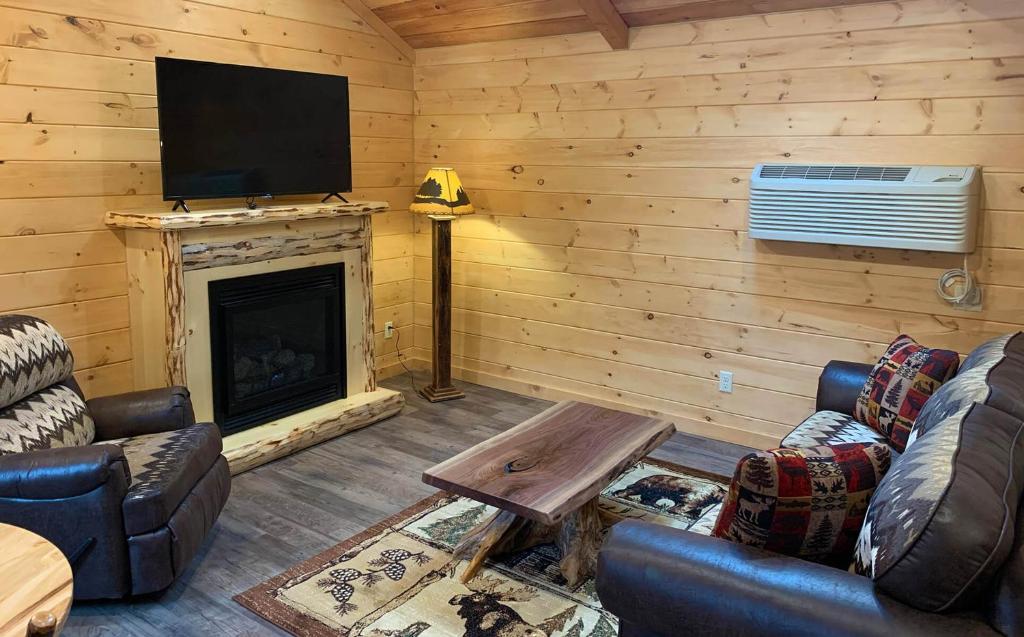 a living room with a fireplace and a flat screen tv at Briarwood Cabin by Amish Country Lodging in Berlin