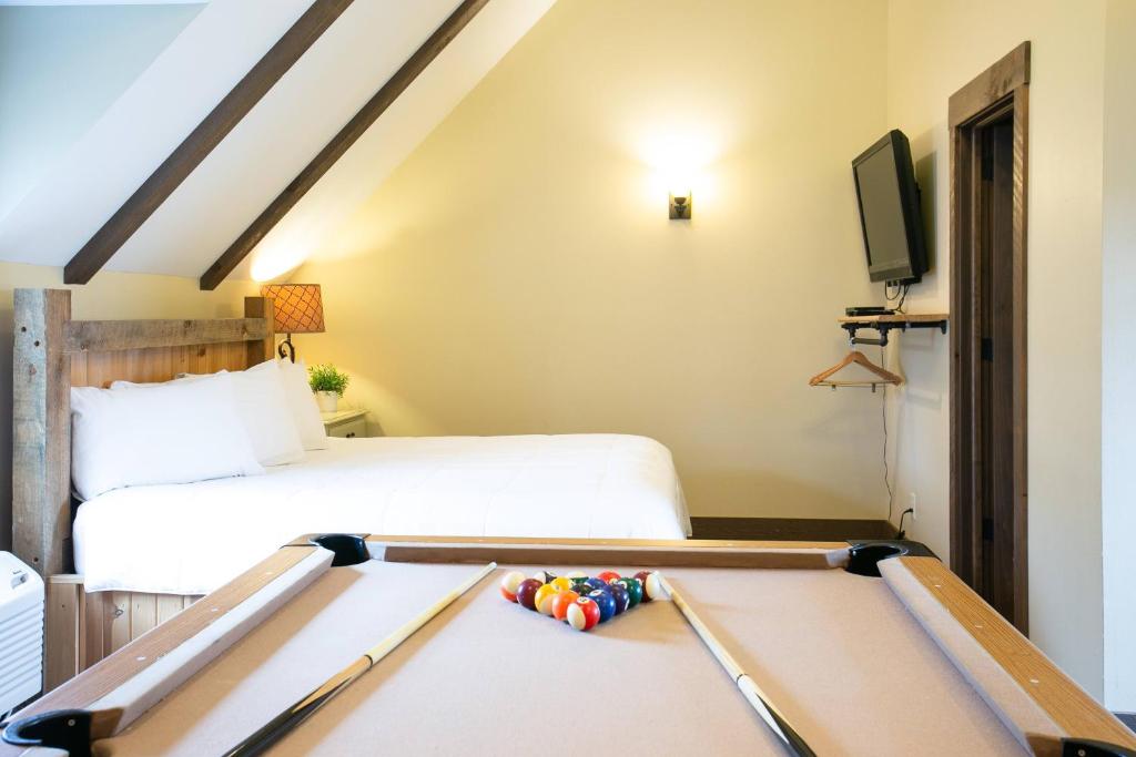 a bedroom with a bed and a pool table at Country Bliss Cottage by Amish Country Lodging in Berlin