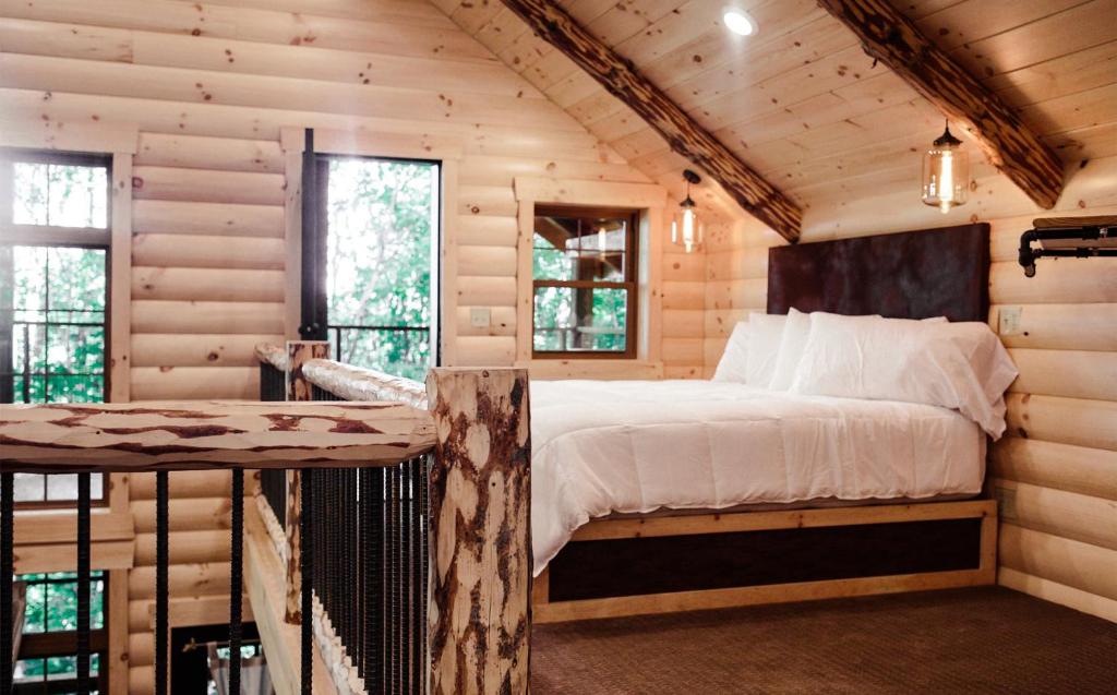 Un dormitorio con una cama en una cabaña de troncos en Treehouse #1 by Amish Country Lodging, en Millersburg