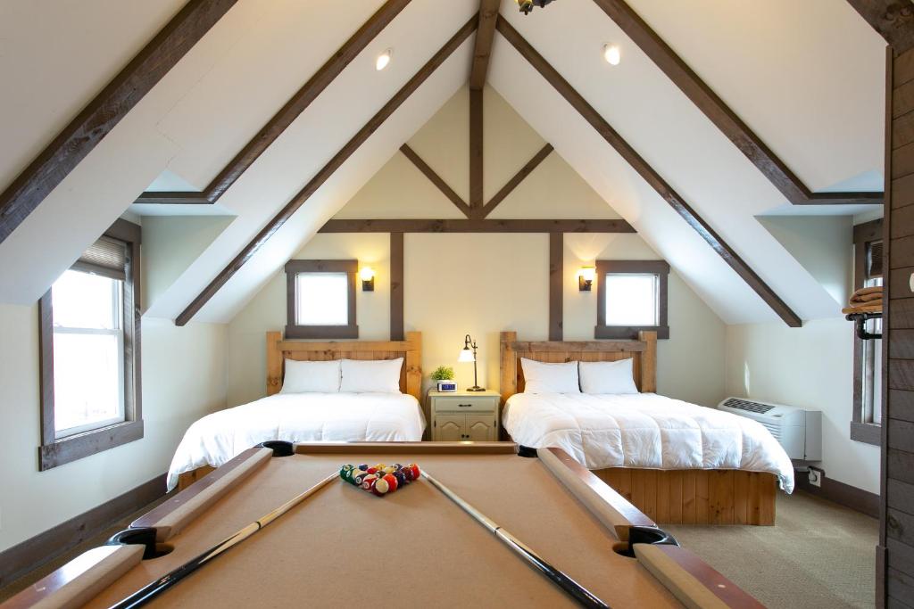 a attic room with a pool table and two beds at Village Dreams Cottage by Amish Country Lodging in Berlin