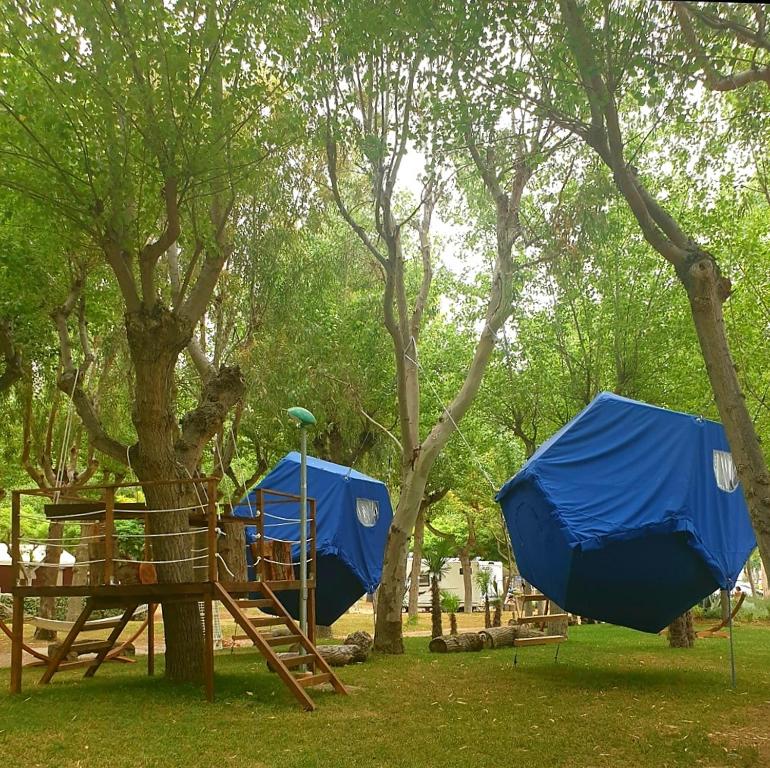 due strutture di gioco blu in un parco con alberi di EurCamping Roseto Concept Glamping a Roseto degli Abruzzi