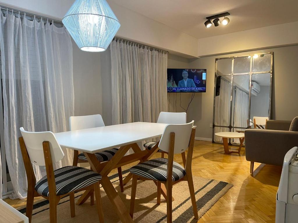 uma sala de jantar com uma mesa branca e cadeiras em Departamento Fabuloso em Rosário