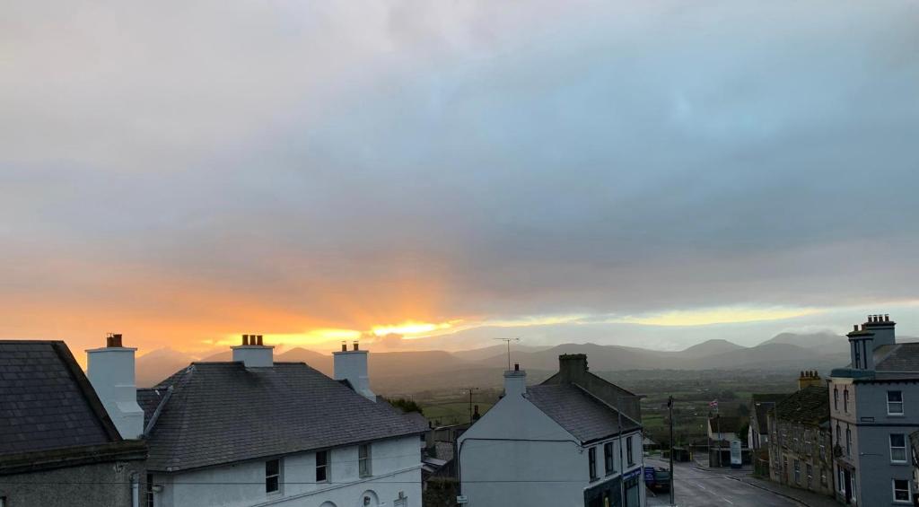 a sunset over a town with houses and buildings at Ringfort Manor in Rathfriland